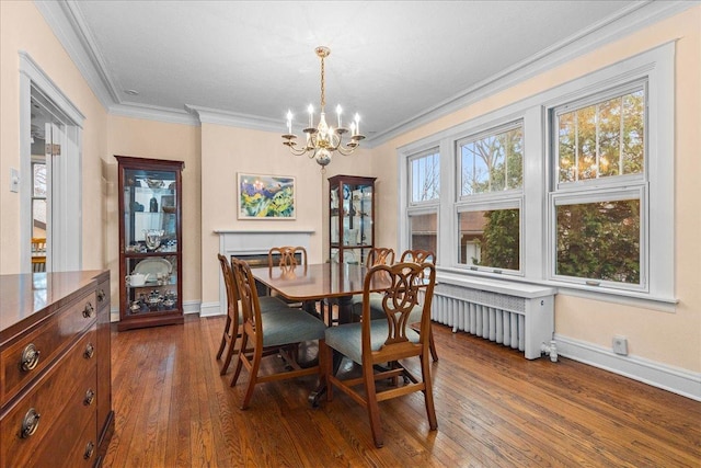 dining room with dark wood-style flooring, baseboards, an inviting chandelier, and crown molding