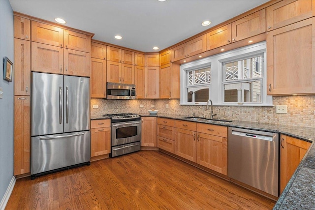 kitchen with decorative backsplash, dark wood-style floors, stainless steel appliances, and a sink