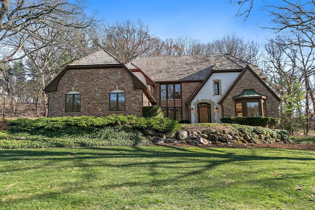 4001 Wyndwood Dr, Crystal Lake, IL 60014 - tudor-style house featuring a front yard, brick siding, and stucco siding