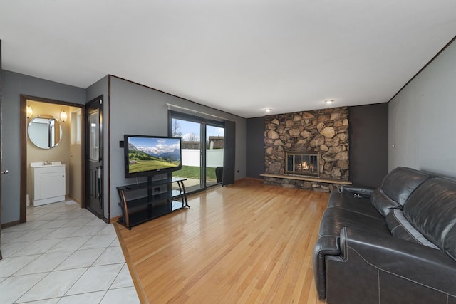 living area with a stone fireplace and light wood finished floors