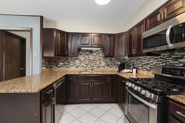 kitchen featuring a sink, light tile patterned floors, light stone countertops, and stainless steel appliances