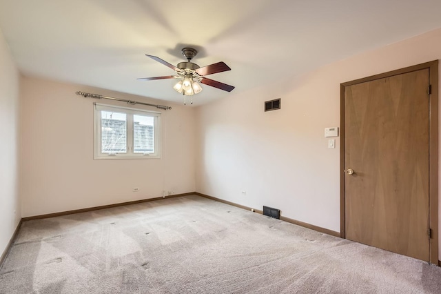 unfurnished room featuring visible vents, light colored carpet, baseboards, and ceiling fan
