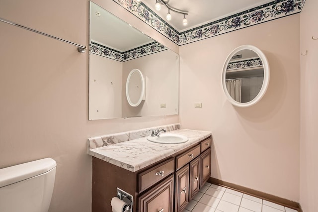 bathroom featuring tile patterned floors, toilet, vanity, and baseboards