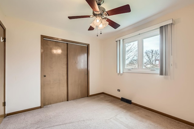 unfurnished bedroom with visible vents, a closet, baseboards, and light carpet
