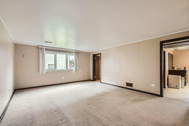 empty room with carpet floors, baseboards, and visible vents