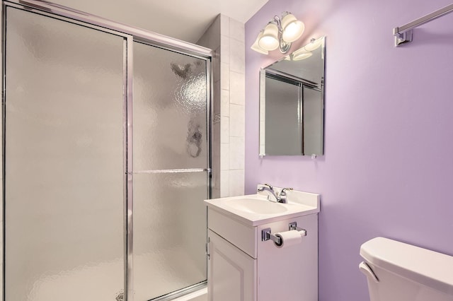 full bath featuring toilet, a shower stall, and vanity