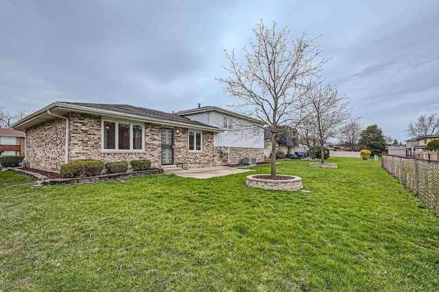 back of property featuring a patio, brick siding, a fenced backyard, and a yard