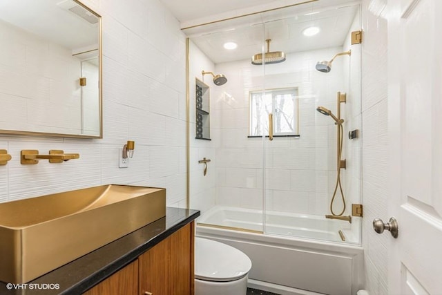 bathroom with vanity, a combined bath / shower with rainfall shower, toilet, visible vents, and tile walls
