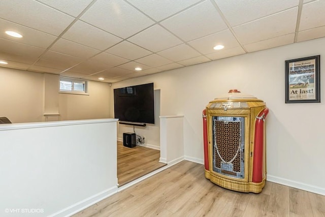 interior space featuring recessed lighting, a drop ceiling, baseboards, and wood finished floors
