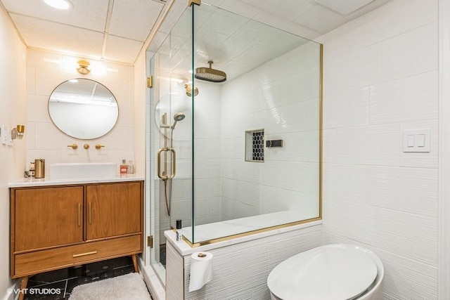 bathroom featuring vanity, tile walls, and a stall shower