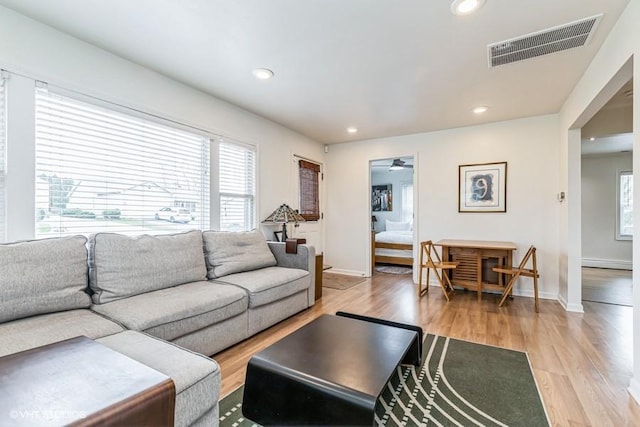 living room with recessed lighting, light wood finished floors, visible vents, and baseboards