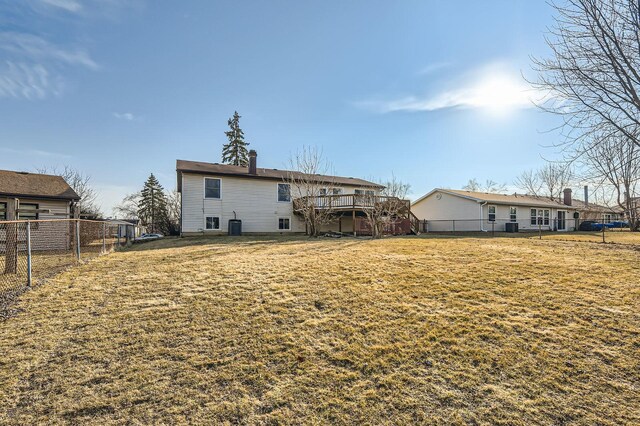 rear view of house with a yard, a wooden deck, and fence private yard