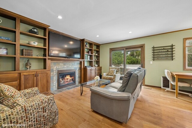 living room with light wood finished floors, baseboards, recessed lighting, a fireplace, and ornamental molding