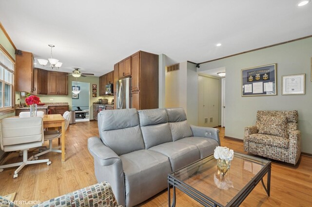 living room with recessed lighting, light wood-type flooring, and visible vents