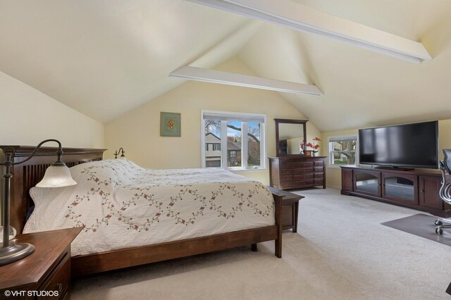 bedroom with lofted ceiling, light colored carpet, and multiple windows
