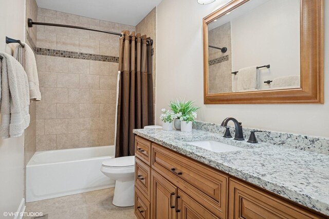 full bath with tile patterned floors, shower / bath combo with shower curtain, vanity, and toilet