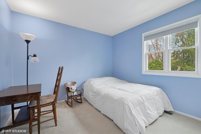 bedroom featuring light carpet and baseboards