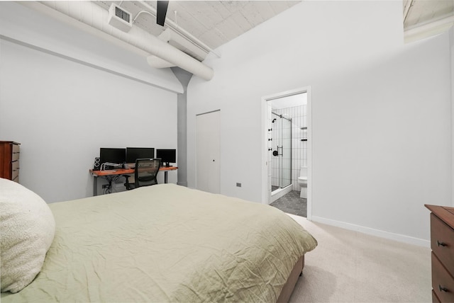 bedroom featuring ensuite bathroom, baseboards, visible vents, a high ceiling, and carpet floors