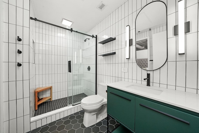 bathroom featuring visible vents, toilet, tile walls, tile patterned floors, and a stall shower
