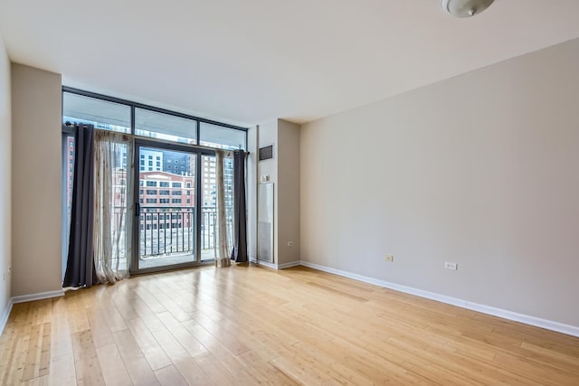 600 N Dearborn St Unit 710, Chicago, IL 60654 - spare room featuring light wood-style flooring, baseboards, and expansive windows