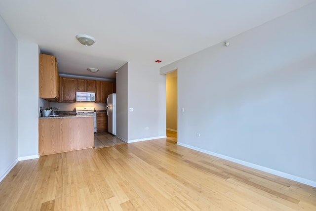 600 N Dearborn St Unit 710, Chicago, IL 60654 - kitchen with light wood-style flooring, open floor plan, baseboards, and white appliances