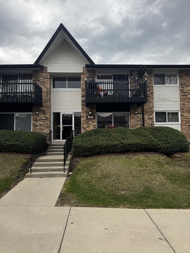 view of front of property featuring a front lawn and brick siding