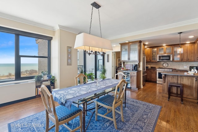 dining area featuring baseboards, an inviting chandelier, ornamental molding, and dark wood-style flooring
