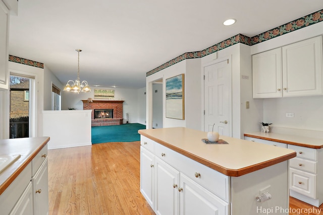 kitchen with open floor plan, light countertops, white cabinetry, and light wood-type flooring