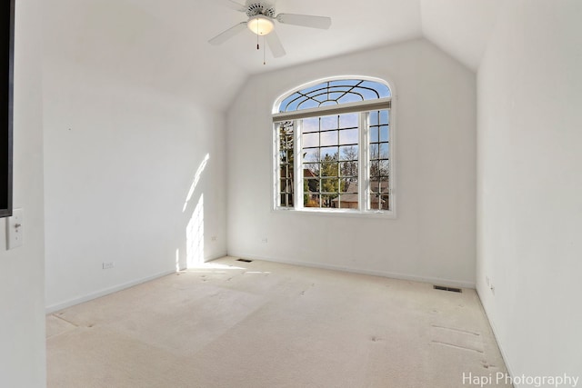 unfurnished room featuring carpet flooring, visible vents, vaulted ceiling, and ceiling fan