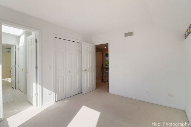 unfurnished bedroom with a closet, carpet flooring, baseboards, and visible vents