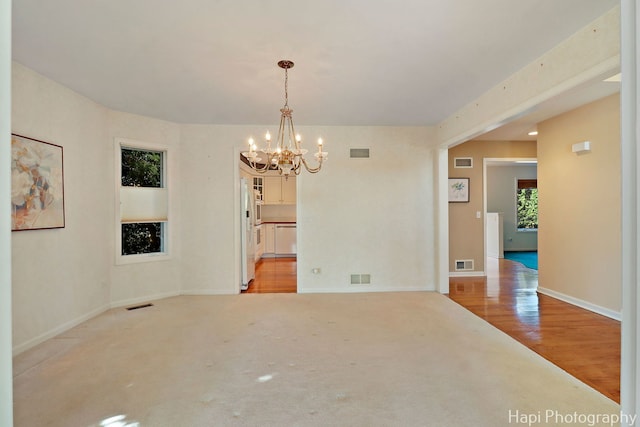 empty room featuring a notable chandelier and visible vents