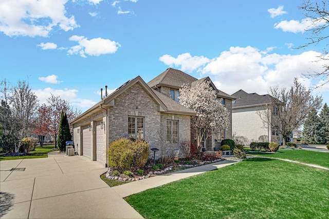 french provincial home with brick siding, driveway, a front yard, and a garage