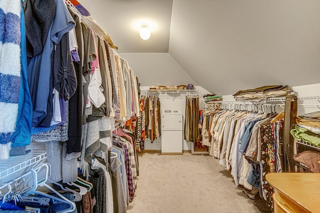 walk in closet featuring light carpet and lofted ceiling