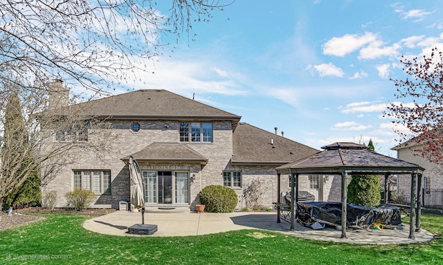 rear view of property featuring a gazebo, a shingled roof, a patio area, and a lawn
