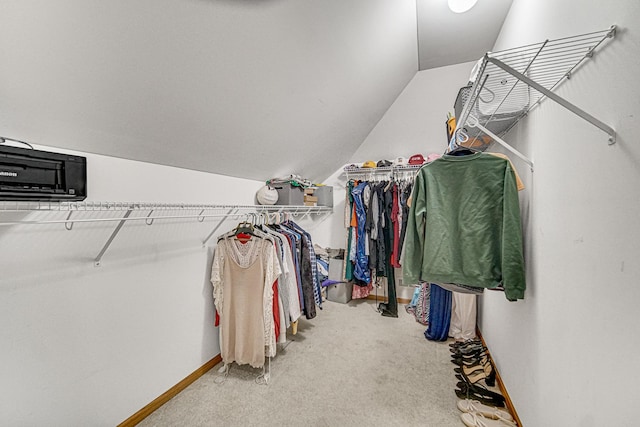 spacious closet featuring carpet flooring and vaulted ceiling