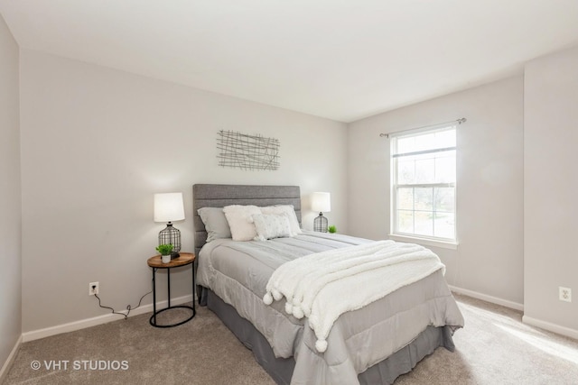 bedroom featuring light carpet and baseboards