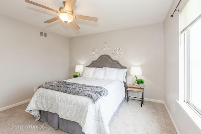 carpeted bedroom featuring visible vents, baseboards, and ceiling fan