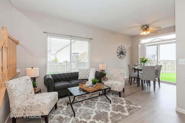 living area featuring ceiling fan, a wealth of natural light, wood finished floors, and baseboards