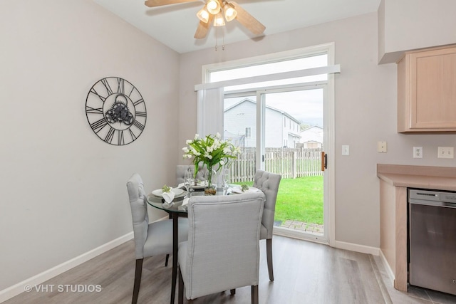 dining space featuring light wood finished floors, a ceiling fan, and baseboards