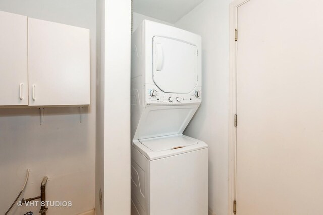 laundry area with stacked washer / drying machine and laundry area