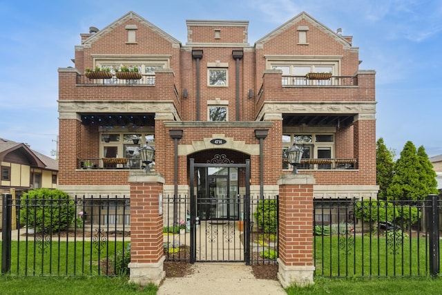 4714 W Berteau Ave Unit 1N, Chicago, IL 60641 - view of front of house with brick siding, a fenced front yard, and a balcony