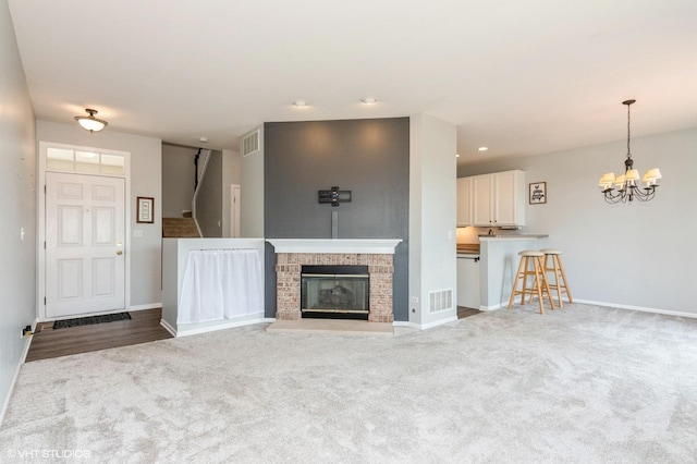 305 Fairmont Ct Unit 305, Saint Charles, IL 60175 - unfurnished living room with carpet flooring, a chandelier, and a fireplace
