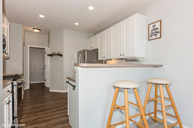 305 Fairmont Ct Unit 305, Saint Charles, IL 60175 - kitchen featuring appliances with stainless steel finishes, white cabinetry, dark wood finished floors, a breakfast bar area, and recessed lighting
