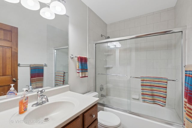 full bath featuring bath / shower combo with glass door, vanity, and toilet