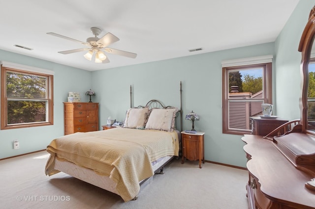 bedroom featuring light colored carpet, multiple windows, and baseboards