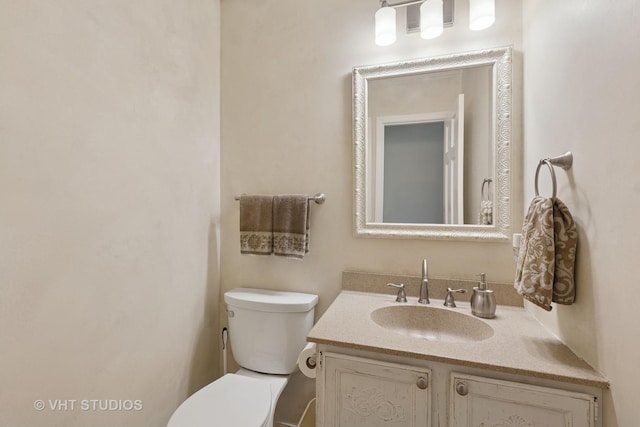 half bathroom featuring toilet and vanity