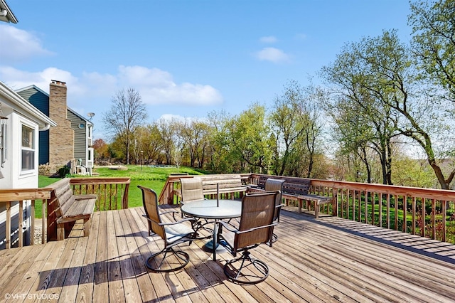 wooden deck featuring outdoor dining space and a yard
