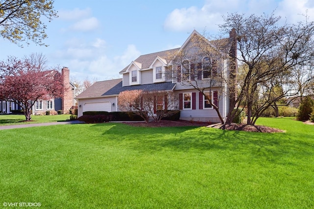 traditional-style house with asphalt driveway, a front lawn, a garage, and a chimney