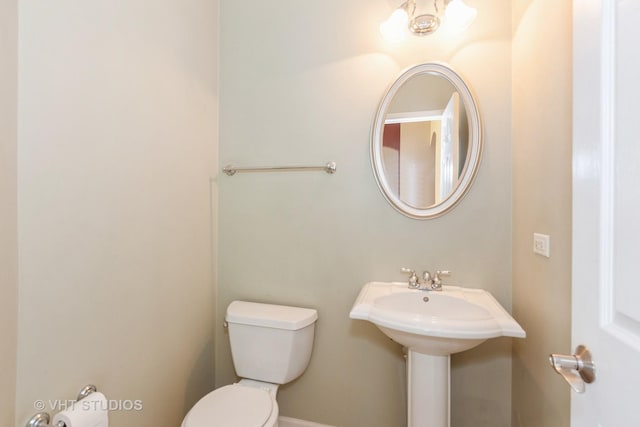 bathroom with toilet and baseboards