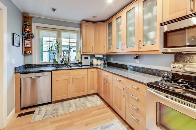 2609 Eisenhower Dr, Des Plaines, IL 60018 - kitchen with stainless steel appliances, light wood-type flooring, dark stone counters, light brown cabinetry, and crown molding